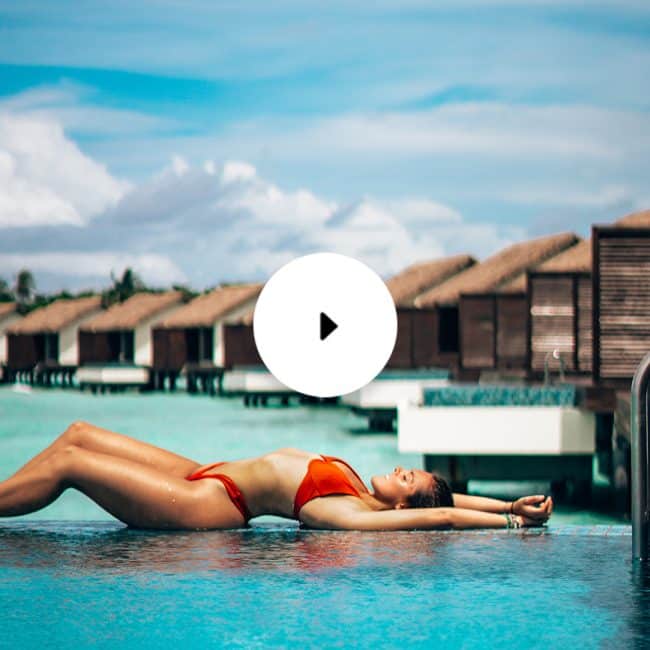 woman lying on pool edge overwater bungalow