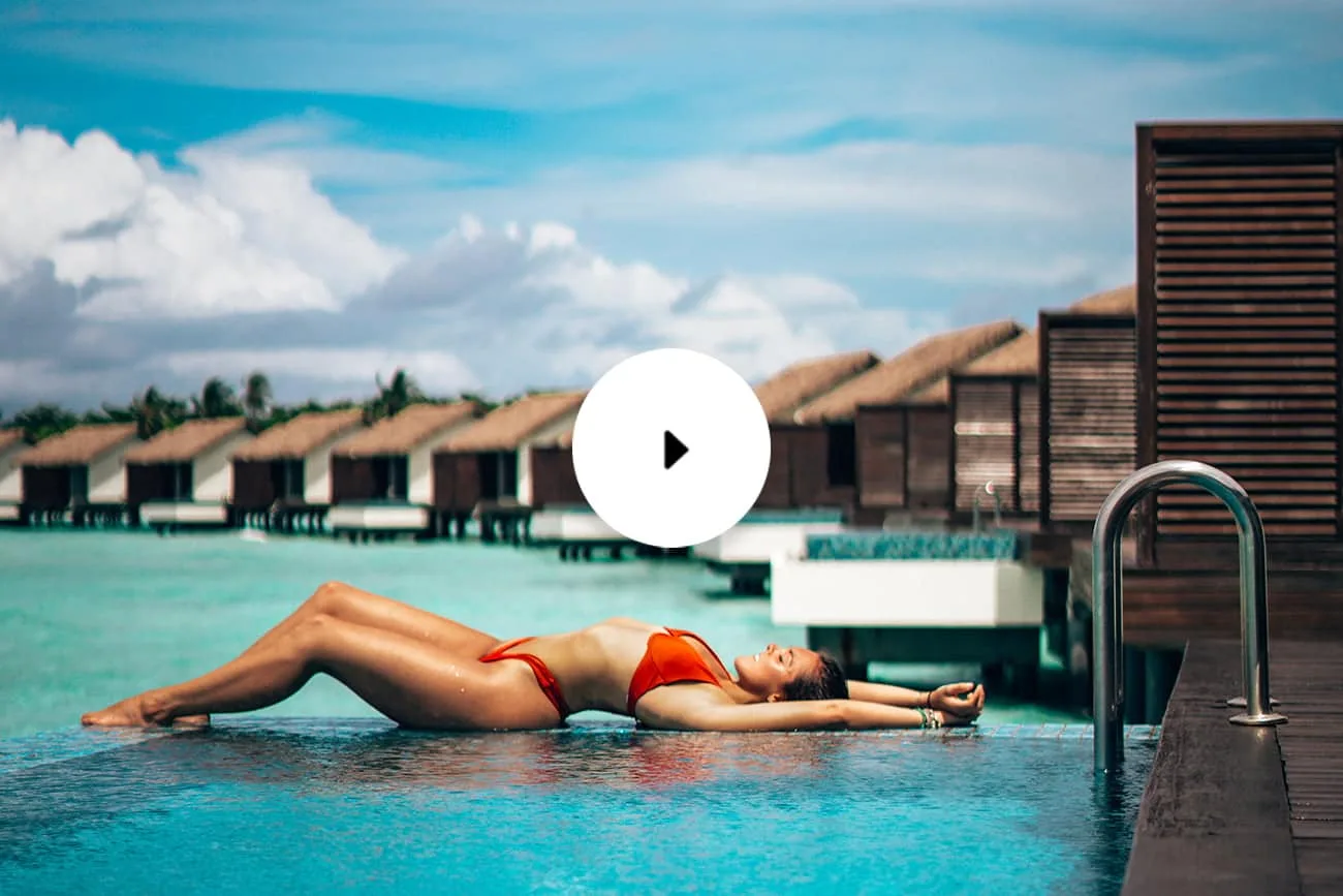 woman lying on pool edge overwater bungalow